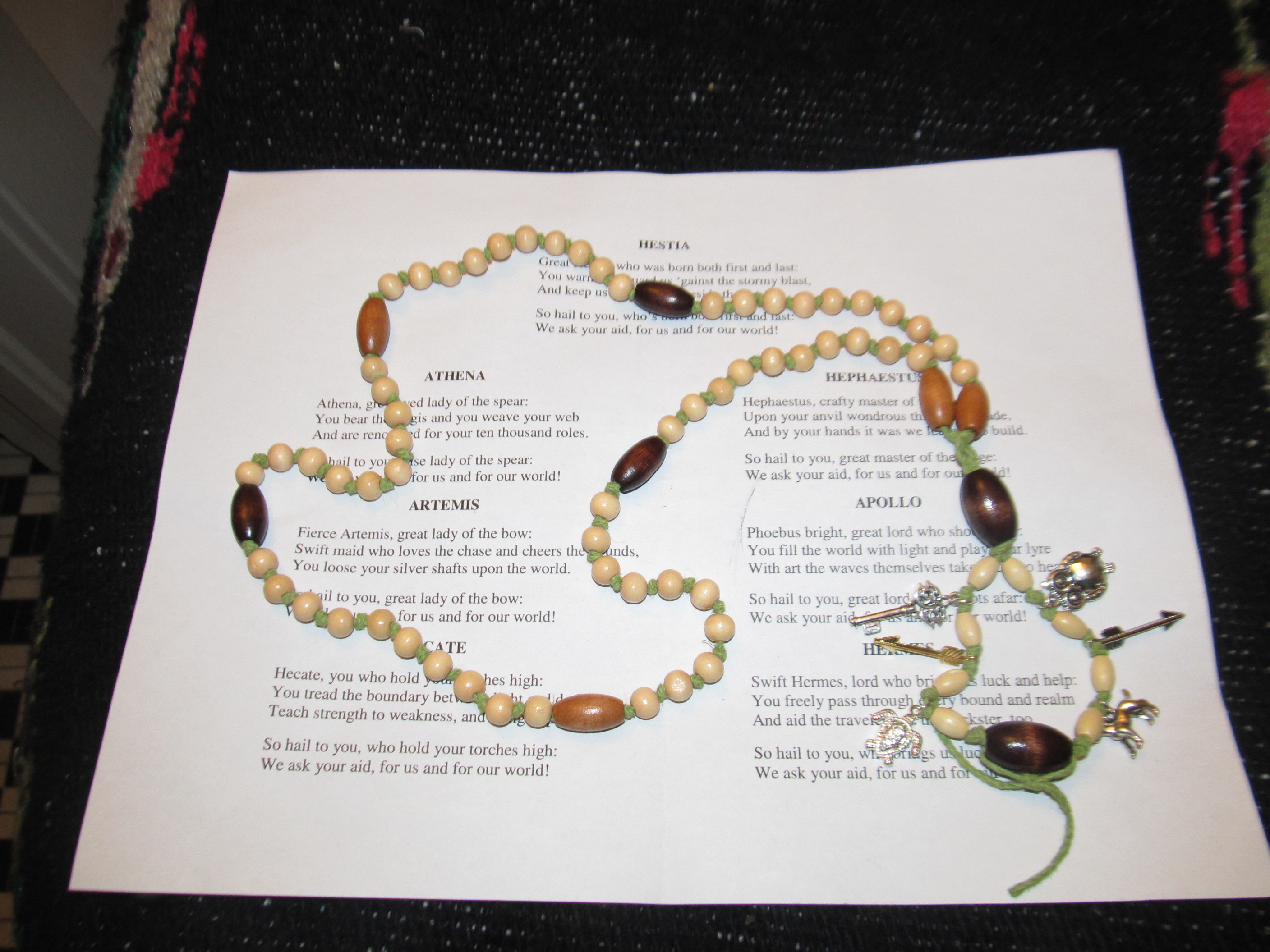 Set of Hellenic pagan prayer beads on top of a set of prayers to be used with them.